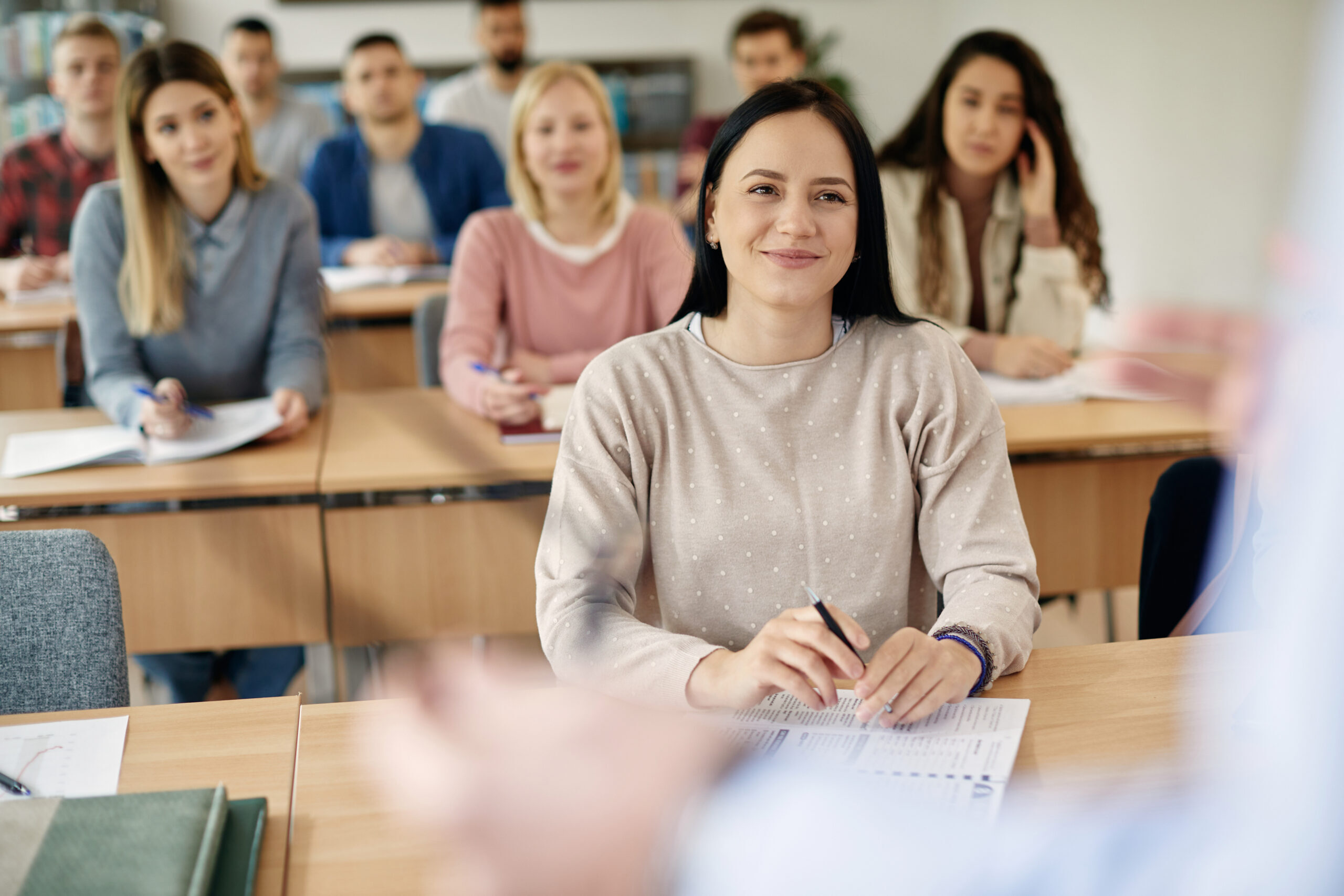 Young smiling woman paying attention during a lecture at the university.