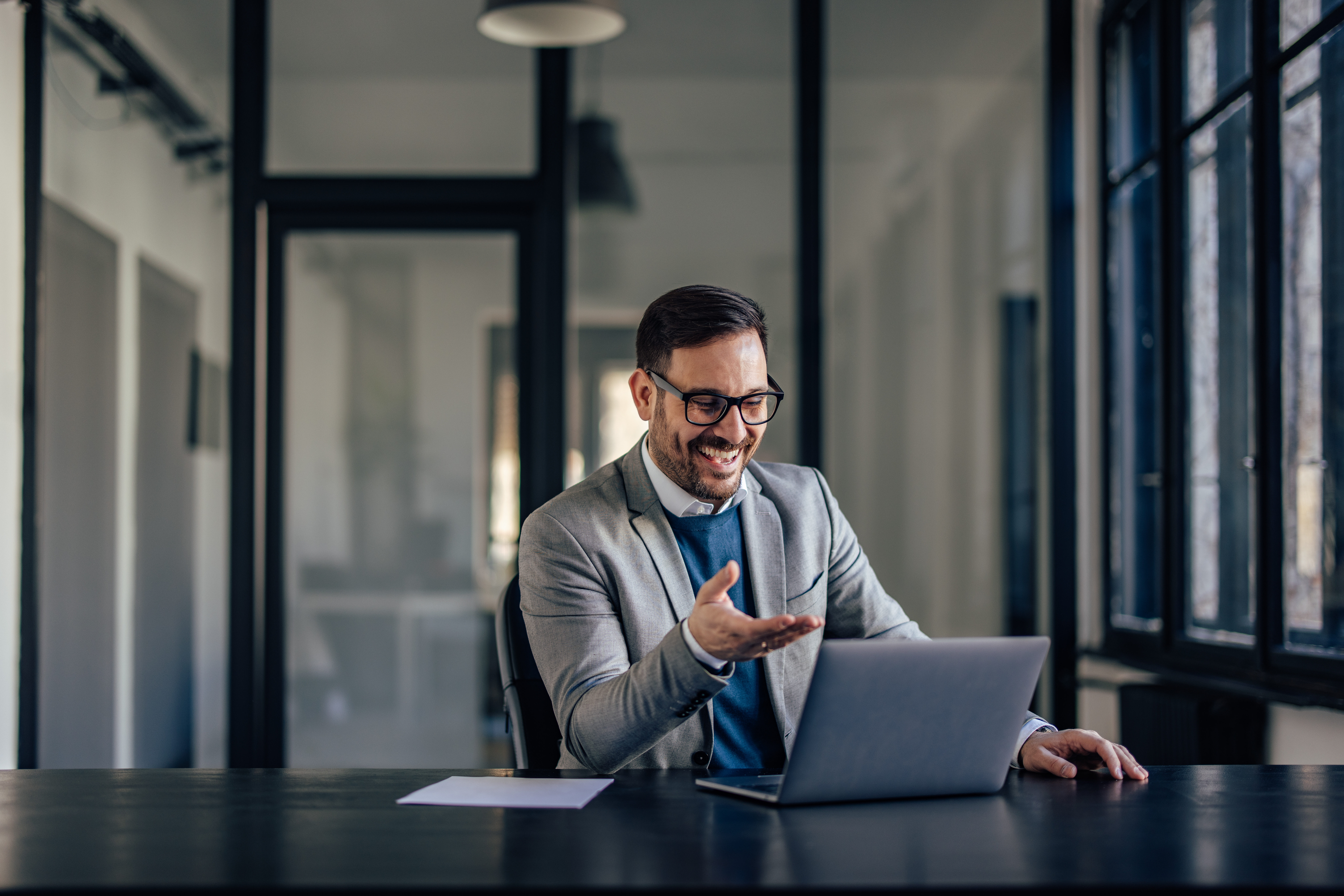 Joyful caucasian man, attending an online meeting, laughing with